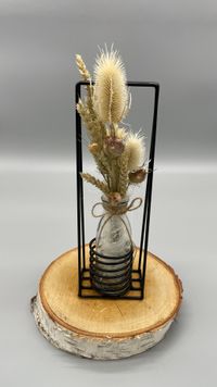 Glasvase mit Metallrahmen und Trockenblumen